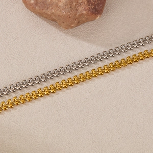 Detail of elegant gold and silver wheat-link bracelets with high-polish metallic texture