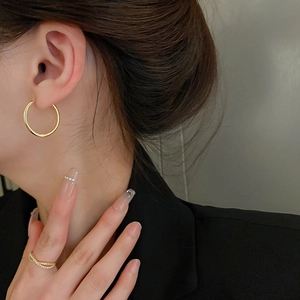 Minimalist small gold geometric hoop earrings for women with polished metallic finish