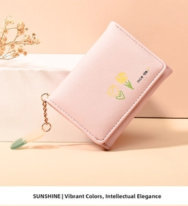 Pink minimalist trifold wallet with tulip print and floral charm on a white stand