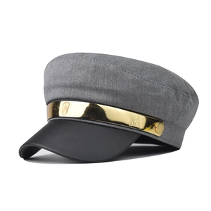 Detail of grey wool blend newsboy cap with black leather brim and metallic M logo