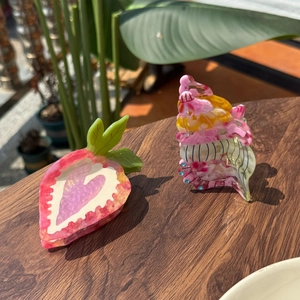 Pinces à cheveux en acétate fraise et coquillage avec strass sur fond en bois