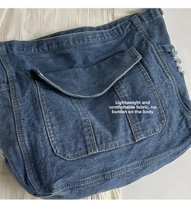 Détail du sac fourre-tout en jean vieilli avec bords effilochés vintage et grande poche