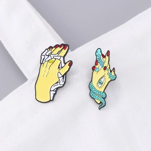 Snake wrap eye palm and skeleton hand enamel pins on white canvas strap