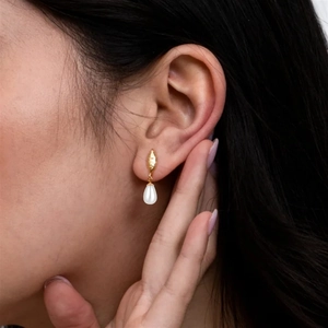 Detailed close-up of golden marquise pearl earrings worn on a person for daily elegance