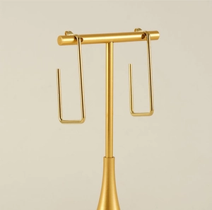 Detail view of gold 18K stainless steel geometric rectangular earrings on T-bar stand