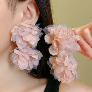 Detail of pink gauze flower earrings featuring delicate tulle petals for women