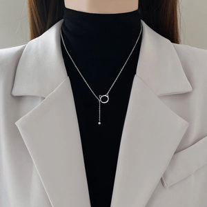 Minimalist cat ear tassel necklace in silver finish worn on model with black clothing