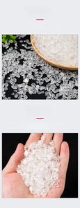 Close-up of polished natural white crystal quartz chips in a wooden tray and hand