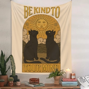 Detail of artistic cat tapestry with 'Be Kind To Your Mind' quote on white wall