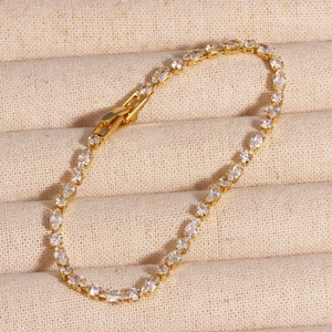Close-up of golden zircon bracelet with marquise-cut stones in a beige jewelry box