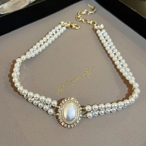 Détail du collier de perles double épaisseur avec pendentif ovale et cristaux