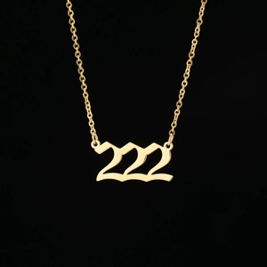 Détail du collier doré avec pendentif chiffre ange 222 en police gothique