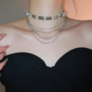 Détail du choker à perles multicouche avec tubes argentés et chaînes perlées en cascade