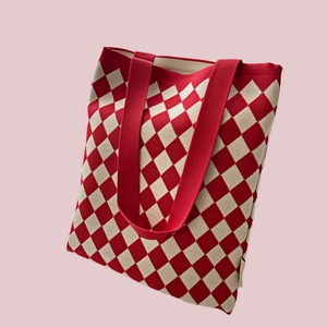 Close-up of red and beige checkered knit tote bag with durable canvas handles