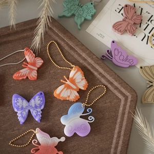 Detailed view of colorful butterfly pendants with textured wings and metal ball chains