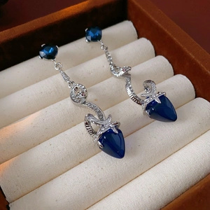 Detail of silver snake pendant earring with dark blue teardrop gemstone and crystals