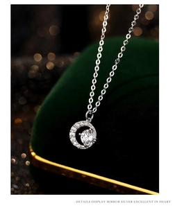 Macro shot of silver crescent moon pendant with sparkling zircon and mirror polish