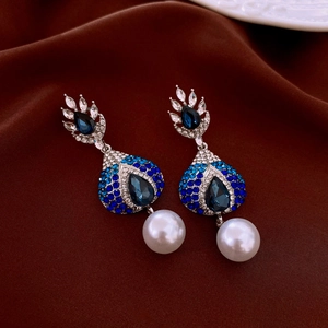 Close-up of vintage teardrop earrings with blue gemstones and large white pearls