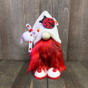 Detailed view of Christmas gnome decoration featuring ladybug motifs and red fur beard