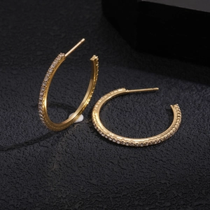 Detail of gold geometric hoop earrings with sparkling micro-inlaid rhinestones
