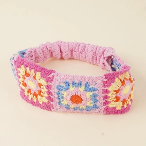 Detailed close-up of handmade boho crochet floral headband with colorful sun pattern