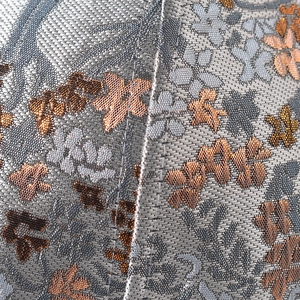 Macro detail of intricate gold silk embroidery and mesh fabric on a baseball cap