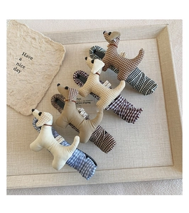 Détail de quatre pinces à cheveux chiot en tissu à carreaux beige et marron sur plateau