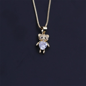 Détail du pendentif ours doré avec micro-diamants et cristal de zircon en forme de cœur