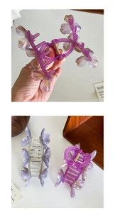 Nahaufnahme lichtdurchlässiger Blumen-Haarklammern in Violett und Grau mit Goldfeder