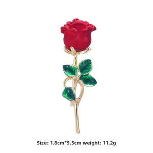 Detailed view of red rose brooch with gold stem and green enamel leaves 1.8x5.5cm