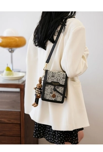 Detail of canvas crossbody phone bag featuring vintage bear patterns and cute charm