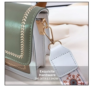 Detail of green and tan bag with leaf embroidery and woven strap with gold lobster clasp