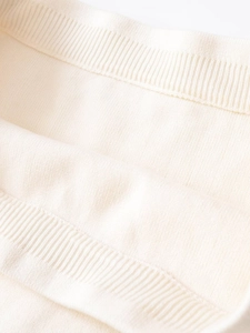 Dettaglio macro della trama del tessuto a maglia a coste color crema e trama elastica
