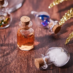 Macro detail of mini corked glass bottles in heart and square shapes on dark wood
