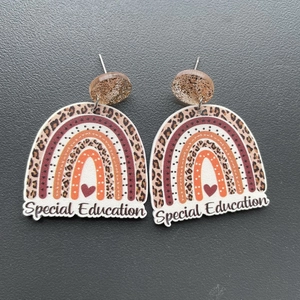 Detail of Special Education acrylic rainbow earrings with leopard print and red hearts