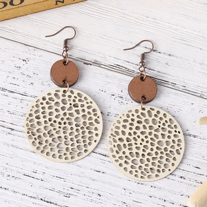 Close-up of bohemian brown and beige geometric hollow wooden disc drop earrings