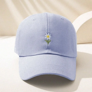 Detailed close-up of daisy embroidery on lilac cotton twill baseball cap fabric