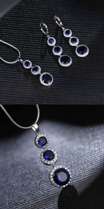 Close-up of silver-tone teardrop necklace and earrings with blue and clear zircon stones
