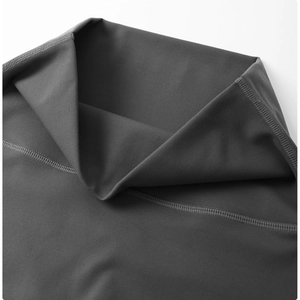 Detailed view of high-waist yoga leggings showing dark gray fabric and fine stitching