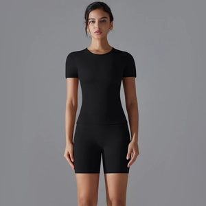 Vue de face de l'ensemble de yoga noir pour femme avec haut à manches courtes et short moulant