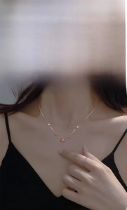 Close-up of S925 silver rainbow circle necklace in rose gold on a model's neck