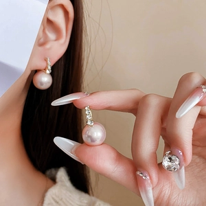 Macro view of luxury lavender pearl earrings with pavé rhinestones on the earlobe