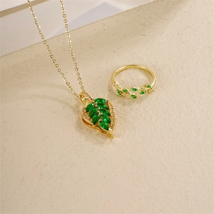 Elegant gold leaf jewelry set featuring green marquise gemstone necklace and matching ring