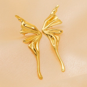 Minimalist 18K gold butterfly wing earrings on luxury champagne satin background