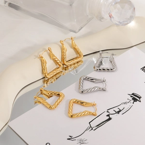 Modern twisted geometric triangle hoop earrings in polished gold and silver steel finish