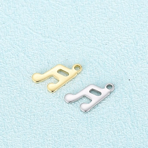 Pendentif note de musique minimaliste en finition dorée et argentée sur fond bleu