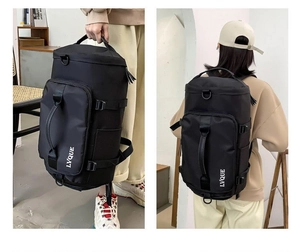 Detail of multi-functional black travel bag showing top handles and adjustable side straps