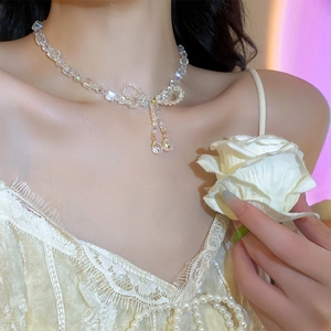 Close-up of elegant bow-shaped crystal necklace with pendant on a model neck