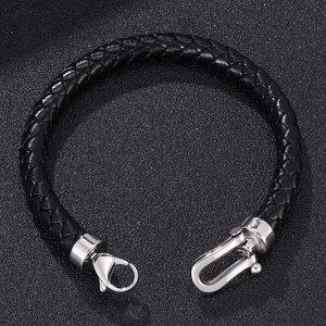 Close-up of black braided leather bracelet with silver horseshoe and lobster clasps