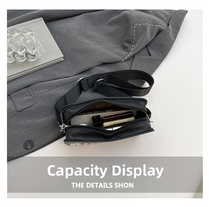 Detail view of the black crossbody bag interior capacity with everyday essentials